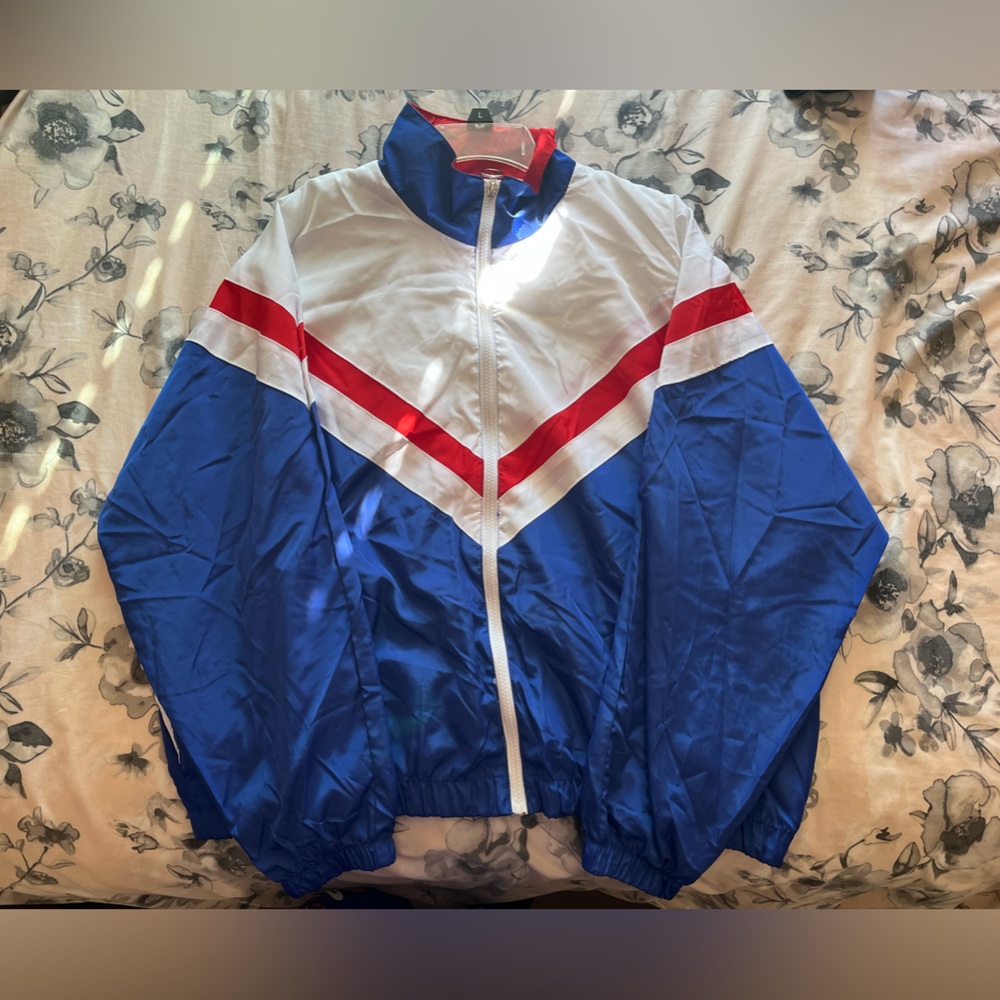 Red, white, and blue windbreaker. Comfortable and thin. Scrunched at the bottom